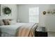 Inviting bedroom featuring neutral tones, decorative pillows, and natural light from the window at 7402 Northfield Blvd, Fishers, IN 46038