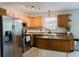 Traditional kitchen featuring wooden cabinets, tile backsplash, and stainless steel refrigerator at 7402 Northfield Blvd, Fishers, IN 46038