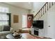 Inviting living room with a cozy fireplace, a staircase, and a view to the entry at 7402 Northfield Blvd, Fishers, IN 46038