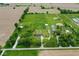 Wide aerial shot showcasing the property with its home, outbuildings, and surrounding farmland at 7447 S 25 E, Pendleton, IN 46064