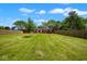 Large, grassy backyard with a full wooden fence and a red brick home at the back at 7447 S 25 E, Pendleton, IN 46064