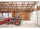 The interior of a barn with a tractor, wooden framing, and partially finished walls at 7447 S 25 E, Pendleton, IN 46064