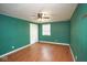 Bedroom with hardwood flooring and green walls featuring a ceiling fan and white trim at 7447 S 25 E, Pendleton, IN 46064