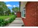 Close up of a red brick home featuring an eye-catching bay window and lush green landscaping at 7447 S 25 E, Pendleton, IN 46064