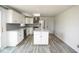 Open kitchen with white cabinets, a stainless steel refrigerator, and a center island with modern countertops at 7447 S 25 E, Pendleton, IN 46064