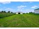 A white outbuilding in a field of green grass with a blue sky and white clouds at 7447 S 25 E, Pendleton, IN 46064