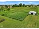 Expansive green property featuring a white shed, surrounded by grass, trees, and fencing at 7447 S 25 E, Pendleton, IN 46064