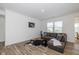 Inviting living room with a modern sofa, wood-look flooring, and natural light from the windows at 794 Harley Ln, Westfield, IN 46074