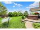 Backyard featuring green lawn, hammock, hot tub, covered patio and well-maintained landscaping at 916 Settlers Walk, Brownsburg, IN 46112