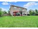 Spacious backyard with a covered patio, hot tub, lush green lawn, and mature trees at 916 Settlers Walk, Brownsburg, IN 46112