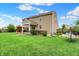 Large backyard featuring well-manicured lawn, patio with grill, hot tub, covered seating area and garden at 916 Settlers Walk, Brownsburg, IN 46112