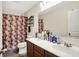 Bright bathroom featuring a double sink vanity, toilet, and shower with patterned curtain for a functional and stylish design at 916 Settlers Walk, Brownsburg, IN 46112