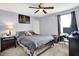 Comfortable bedroom featuring a ceiling fan, neutral walls, carpeted floor, and a well-lit workspace with a monitor and desk at 916 Settlers Walk, Brownsburg, IN 46112