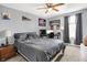 Cozy bedroom featuring a bed, workspace with monitor, and ceiling fan; wall decorations and window with curtains enhance the ambiance at 916 Settlers Walk, Brownsburg, IN 46112