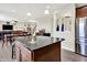 Open concept kitchen view to dining and living room with hardwood floors and stainless refrigerator at 916 Settlers Walk, Brownsburg, IN 46112