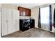 Functional laundry room with modern washer and dryer, storage cabinets, hardwood floor, and natural light from the window at 916 Settlers Walk, Brownsburg, IN 46112