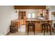 Finished basement bar with wood paneling, cabinets, and high-top chairs at 9601 Irishmans Run Ln, Zionsville, IN 46077