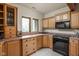Finished basement wet bar area with wood cabinets, countertops, and black appliances at 9601 Irishmans Run Ln, Zionsville, IN 46077