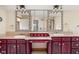 Bathroom featuring and sinks, vanity with red cabinetry and a large mirror with decorative framing at 9601 Irishmans Run Ln, Zionsville, IN 46077