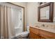 Bathroom featuring a shower with curtain, neutral vanity, patterned mirror, toilet and natural light at 9601 Irishmans Run Ln, Zionsville, IN 46077