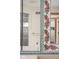 Close-up of floral detail on the tiled mirror frame in a bathroom with a shower, tub, and white storage cabinets at 9601 Irishmans Run Ln, Zionsville, IN 46077