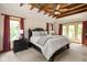 Spacious main bedroom with trey ceiling and large windows with red curtains at 9601 Irishmans Run Ln, Zionsville, IN 46077