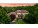 Dusk view of the stately home featuring a tile roof and lush green surroundings at 9601 Irishmans Run Ln, Zionsville, IN 46077