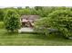 Stunning aerial view of the home with lush greenery, mature trees and circular driveway at 9601 Irishmans Run Ln, Zionsville, IN 46077
