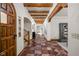 Hallway features tiled floors, exposed beams, arched doorways, and staircase, offering a view through the home at 9601 Irishmans Run Ln, Zionsville, IN 46077