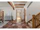 Inviting foyer with stone tile flooring, wooden beams, staircase, and arched doorway at 9601 Irishmans Run Ln, Zionsville, IN 46077