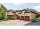 Elegant three-car garage featuring red doors, stone accents, and a tile roof at 9601 Irishmans Run Ln, Zionsville, IN 46077