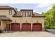 This is a three-car garage featuring red doors, sconce lighting, and a beautiful tiled roof at 9601 Irishmans Run Ln, Zionsville, IN 46077
