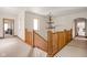 Hallway with wooden banister and antler chandelier creates a welcoming space at 9601 Irishmans Run Ln, Zionsville, IN 46077