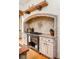 Close up of the custom stovetop and range hood featuring ornate tile and design in the kitchen at 9601 Irishmans Run Ln, Zionsville, IN 46077