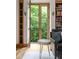 Bright living room with wood floors, built-in shelves, and French doors to a balcony with nature views at 9601 Irishmans Run Ln, Zionsville, IN 46077