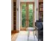 Bright living room with wood floors, built-in shelves, and French doors to a balcony with nature views at 9601 Irishmans Run Ln, Zionsville, IN 46077