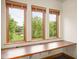 Well-lit office space featuring three large windows overlooking a lush green landscape and a built-in desk at 9601 Irishmans Run Ln, Zionsville, IN 46077