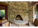 An outdoor stone fireplace surrounded by firewood, with an entrance to a patio at 9601 Irishmans Run Ln, Zionsville, IN 46077