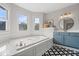 Bright bathroom featuring a soaking tub with tile surround, modern vanity, and patterned tile floor at 9973 Woods Edge Dr, Fishers, IN 46037