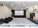 Basement home theater with projector screen, fireplace, and comfortable seating at 9973 Woods Edge Dr, Fishers, IN 46037