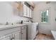 Well-lit laundry room with white cabinets, modern washer and dryer, and a sink at 9973 Woods Edge Dr, Fishers, IN 46037