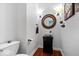 Modern powder room with hardwood floors, vessel sink, and stylish round mirror at 9973 Woods Edge Dr, Fishers, IN 46037