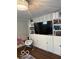 Stylish living room featuring built-in storage, a large TV, and a modern chandelier. Hardwood floors at 101 E Hill Valley E Dr, Indianapolis, IN 46227