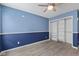 Bright bedroom with stylish two-toned walls, wood-look flooring, and closet storage at 10693 Newgate Ln, Indianapolis, IN 46231