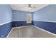 Cozy bedroom with stylish two-toned walls, wood-look flooring, and a ceiling fan at 10693 Newgate Ln, Indianapolis, IN 46231
