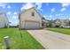 A view of the front of the home with a two car garage and long driveway at 10693 Newgate Ln, Indianapolis, IN 46231