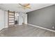 Open bedroom featuring wood-look flooring, a ceiling fan, and a barn door to the bathroom at 10693 Newgate Ln, Indianapolis, IN 46231