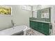 Bright bathroom featuring a soaking tub, double vanity, and decorative tile flooring at 11244 Blackwalnut Pt, Indianapolis, IN 46236