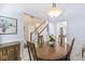 Elegant dining room with hardwood table, chandelier, and view of staircase to upper level at 11244 Blackwalnut Pt, Indianapolis, IN 46236