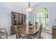 Bright dining room featuring hardwood table, china cabinet and arched stained glass window at 11244 Blackwalnut Pt, Indianapolis, IN 46236